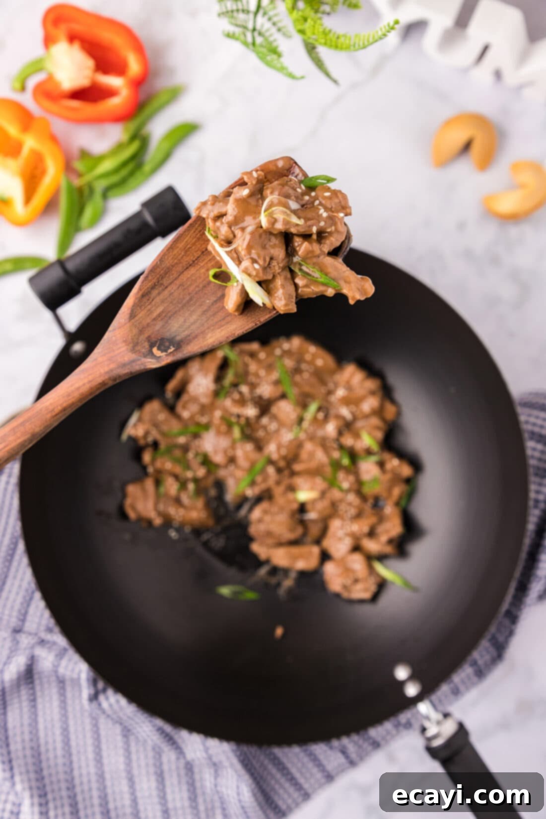 Savory Teriyaki Beef 2 Spoonful of Beef Teriyaki held above a skillet of Beef Teriyaki