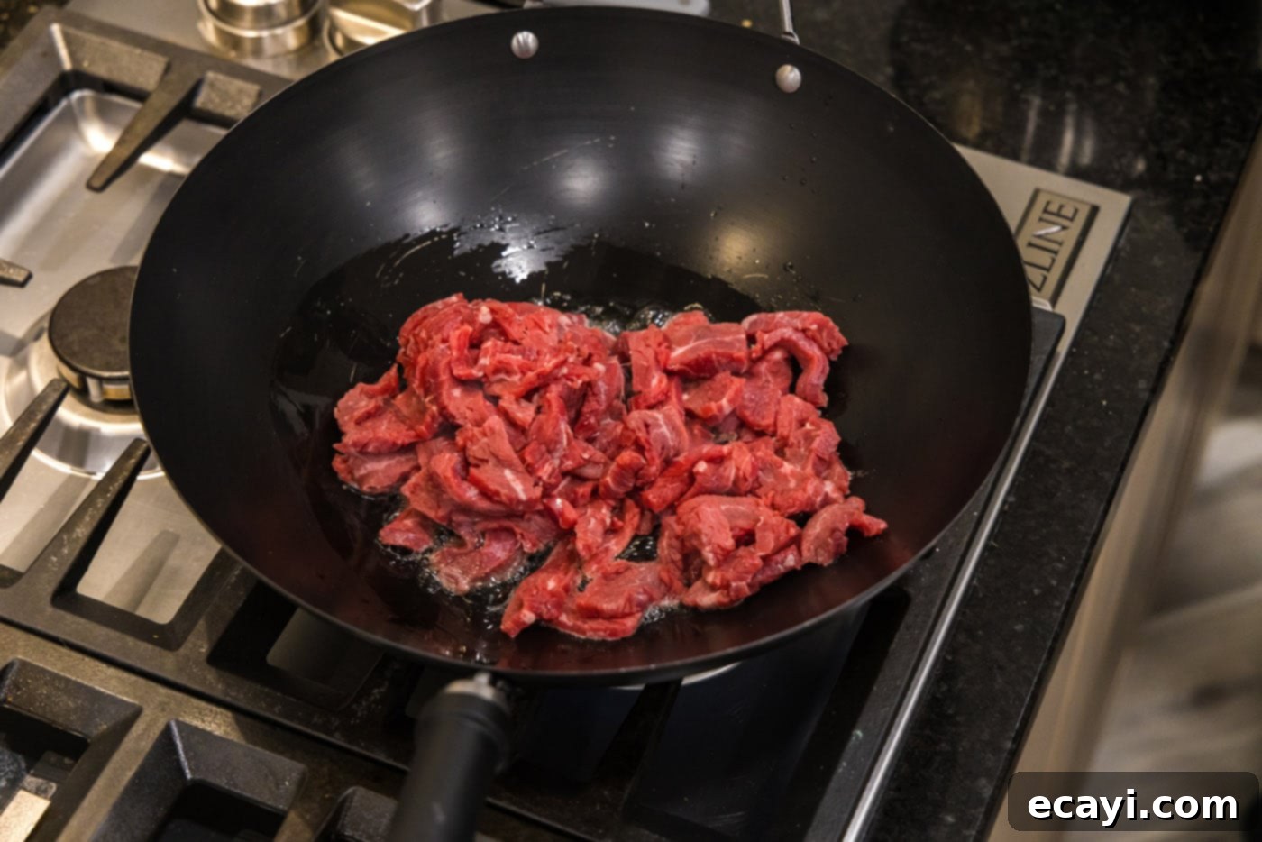 Savory Teriyaki Beef 6 flank steak strips in a wok with oil