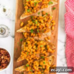 Hearty Beans, Crispy Toast 5 Beans on Toast on a wooden platter, a British comfort food