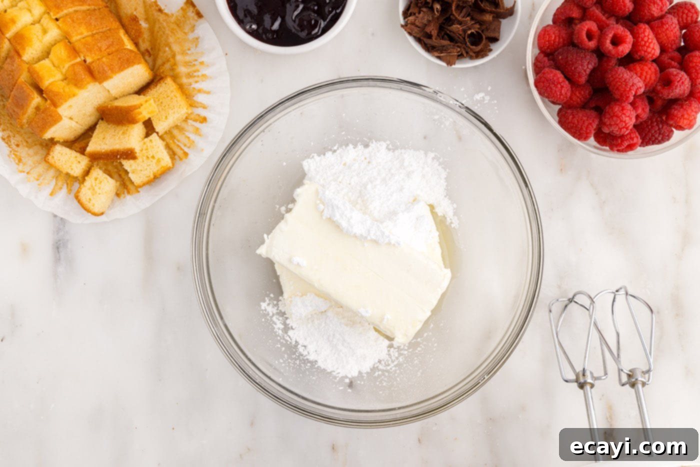 Raspberry Trifle 5 cream cheese, lemon juice, and powdered sugar being beaten in a mixing bowl until smooth