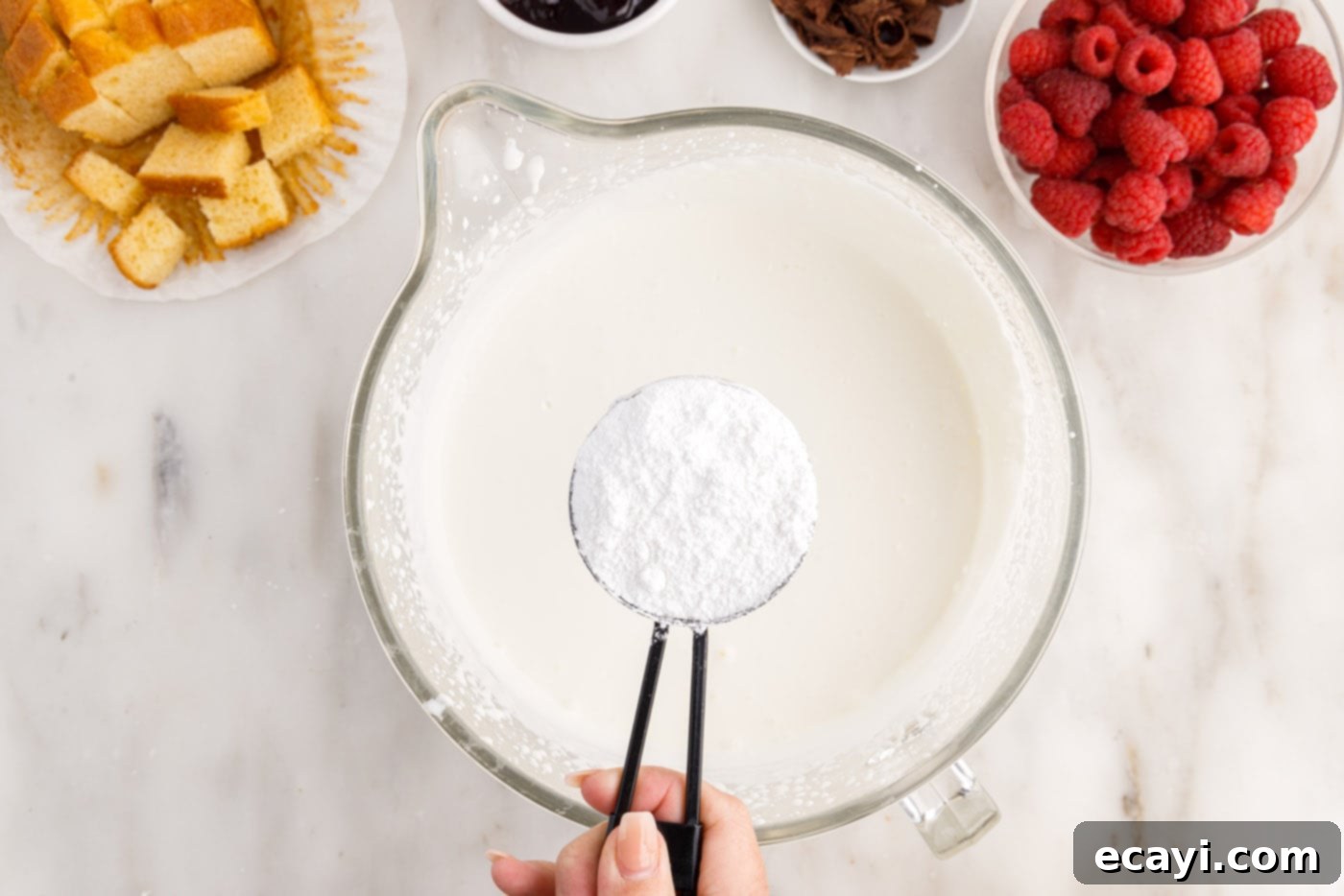Raspberry Trifle 7 adding powdered sugar to heavy whipping cream in a bowl for whipping