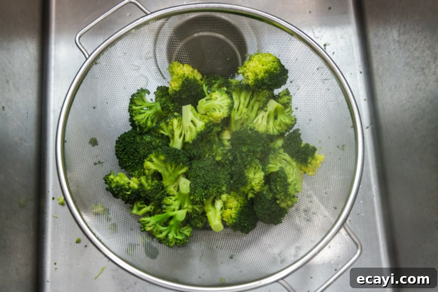 Perfect Instant Pot Broccoli 8 broccoli florets being drained in a strainer