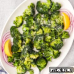 Perfect Instant Pot Broccoli 10 Instant Pot Broccoli on a white platter with onions and lemon wedges
