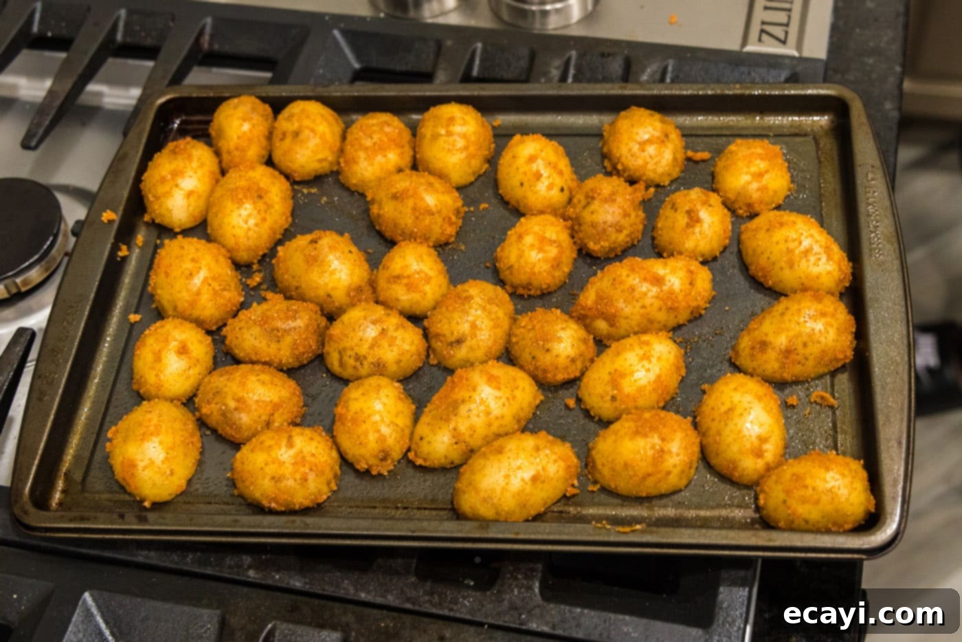 Crispy Parmesan Potatoes 11 Seasoned sliced potatoes arranged cut side down in a single layer on a baking sheet, ready for roasting