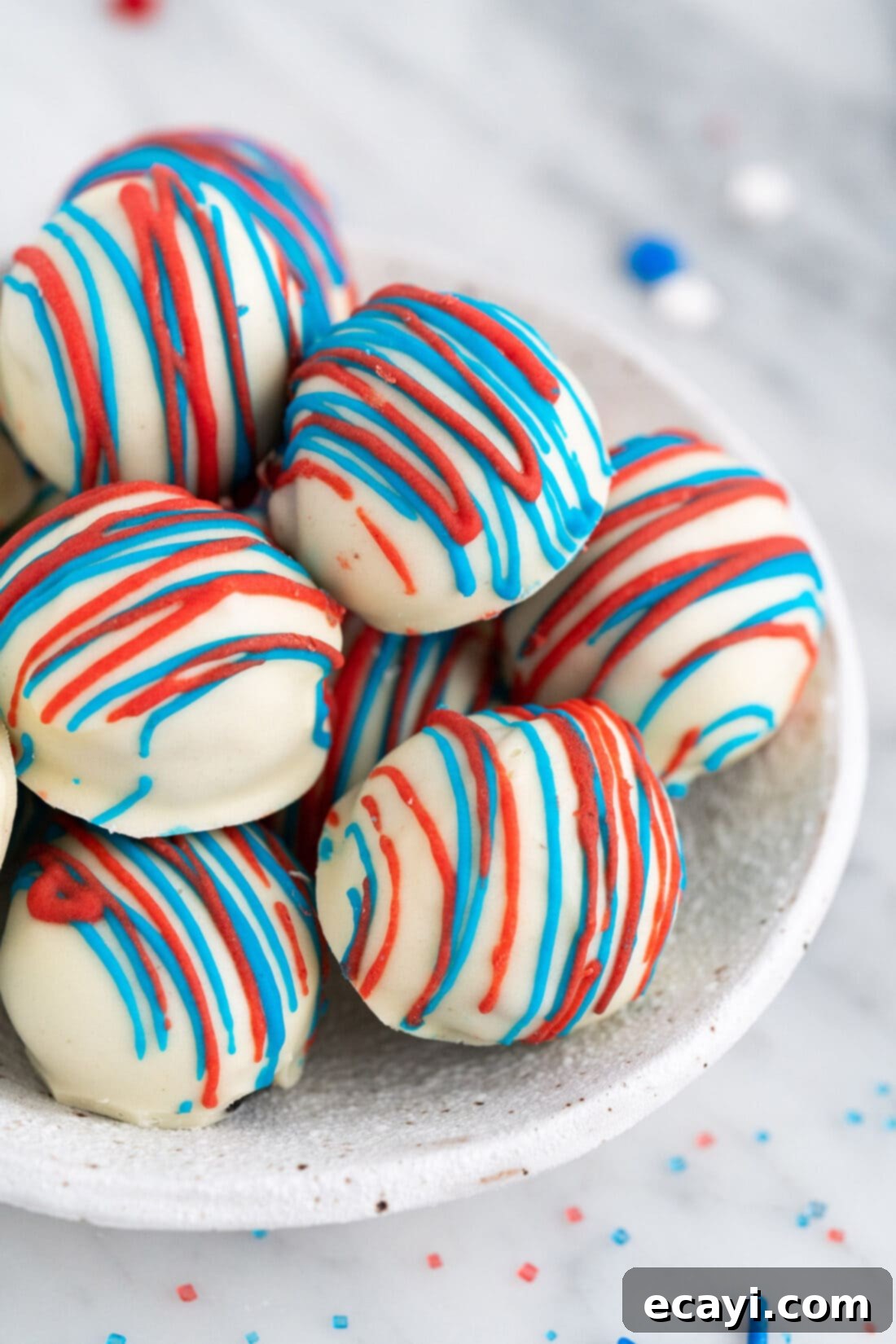 Stars and Stripes Oreo Truffles 3 Bowl of Red White and Blue Oreo Truffles decorated with sprinkles and chocolate drizzles