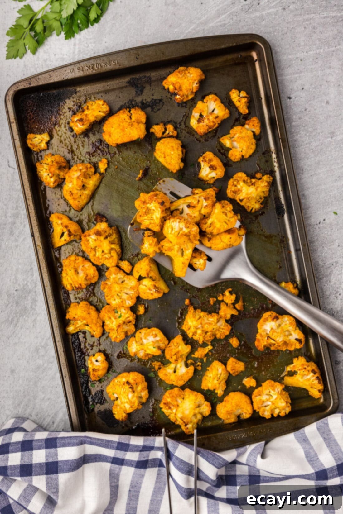 Blistered Spicy Cauliflower 2 Spicy Roasted Cauliflower on a sheet pan with a spatula