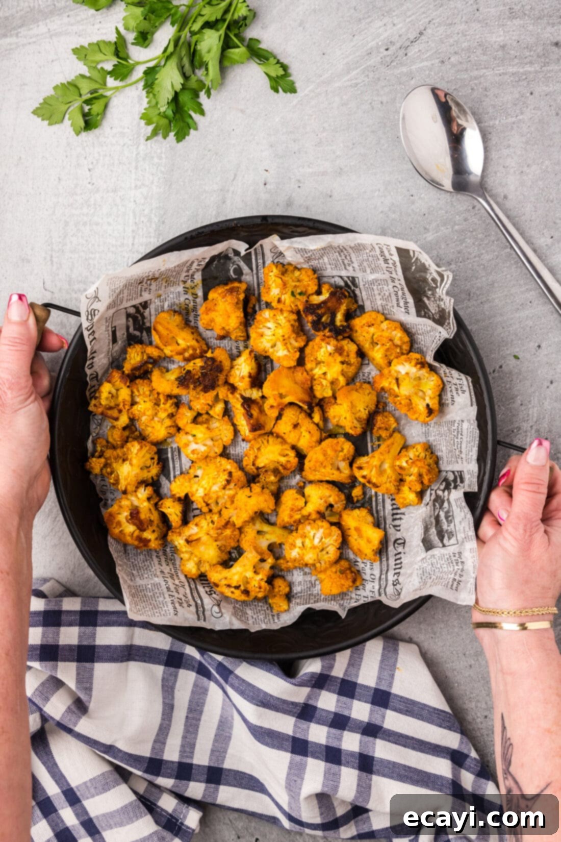 Blistered Spicy Cauliflower 3 Hands holding a serving tray of Spicy Roasted Cauliflower