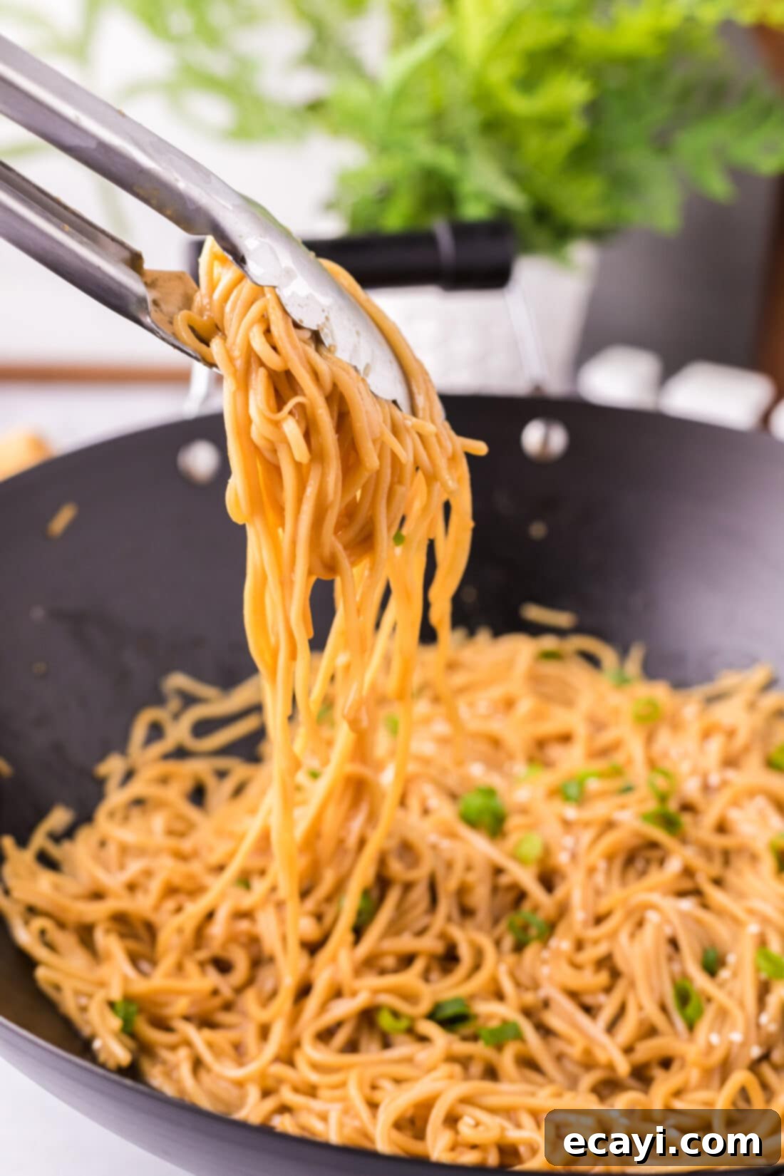 Sweet Sticky Teriyaki Noodles 3 Tongs picking up Teriyaki Noodles from a wok