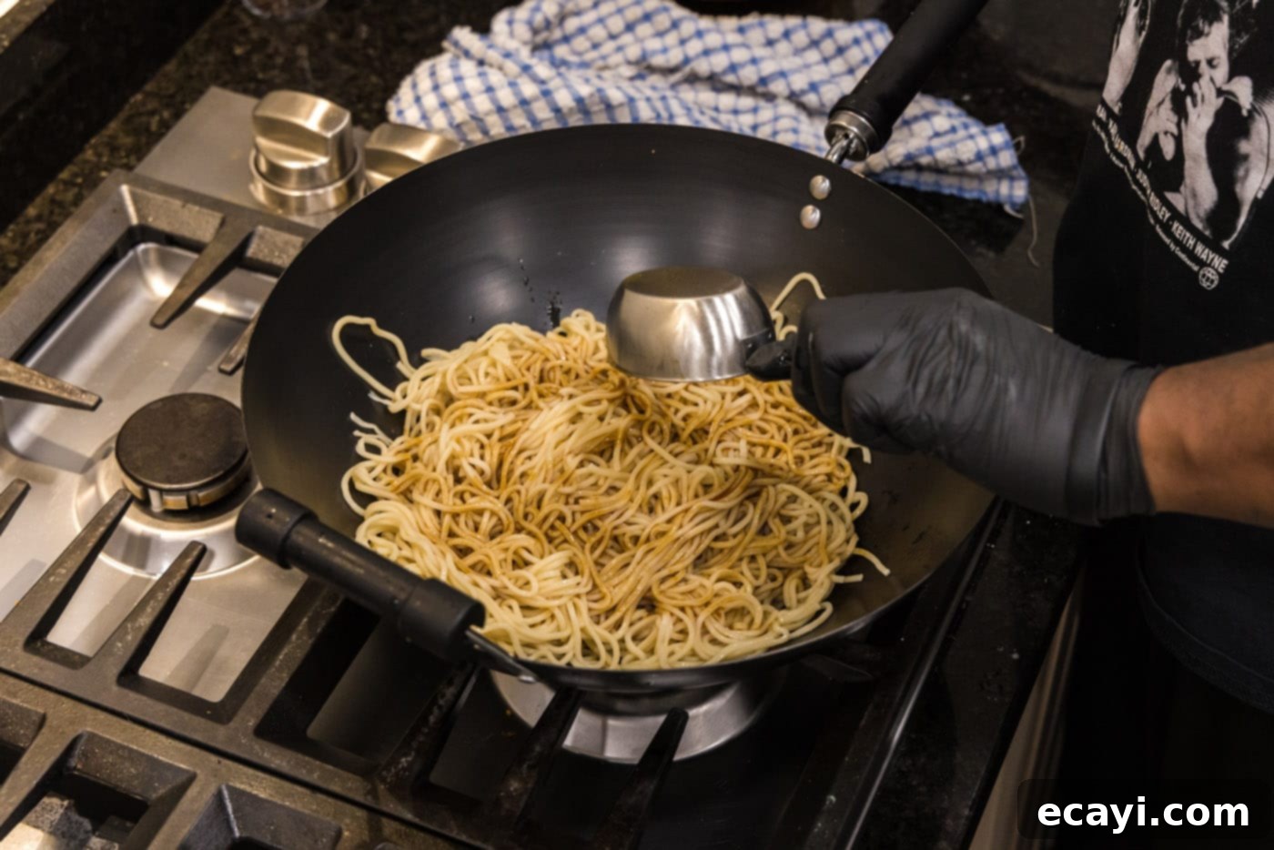 Sweet Sticky Teriyaki Noodles 7 adding teriyaki sauce to lo mein noodles in a wok