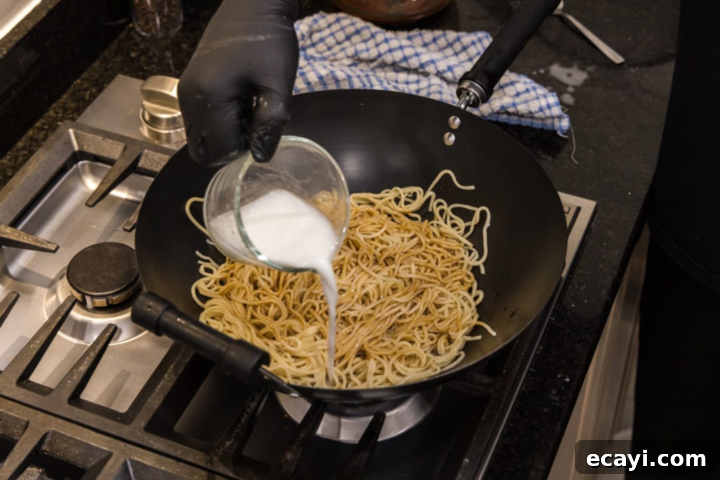 Sweet Sticky Teriyaki Noodles 8 pouring a cornstarch slurry into teriyaki noodles