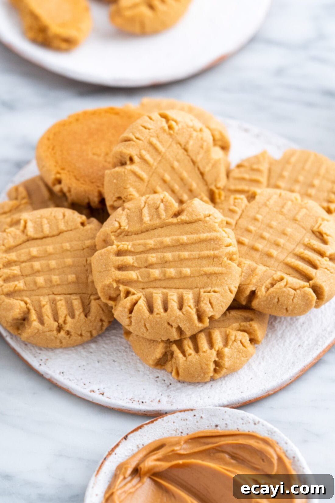 Peanut Butter Cake Mix Delights 3 A plate full of golden brown Peanut Butter Cake Mix Cookies with fork marks.