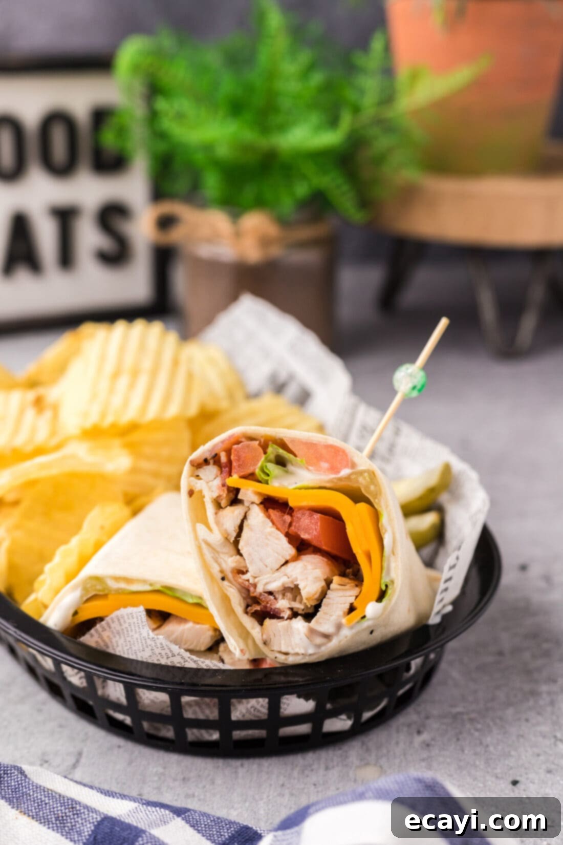 Signature Chicken Bacon Ranch Wrap 2 Chicken Bacon Ranch Wrap in a basket with chips, showcasing a perfectly rolled and cut wrap ready to eat.