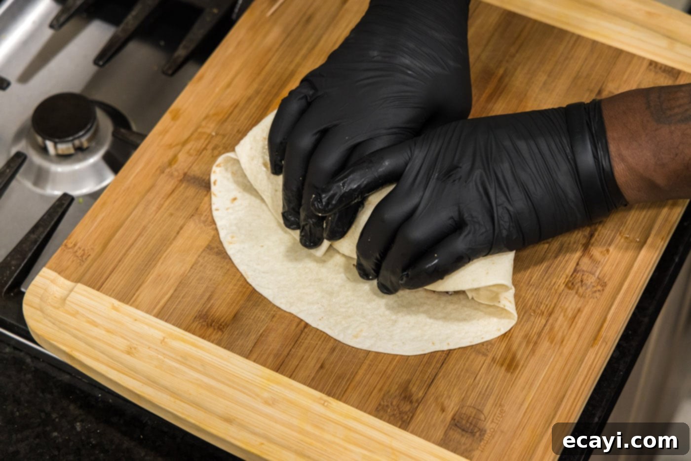 Signature Chicken Bacon Ranch Wrap 12 hands rolling a burrito