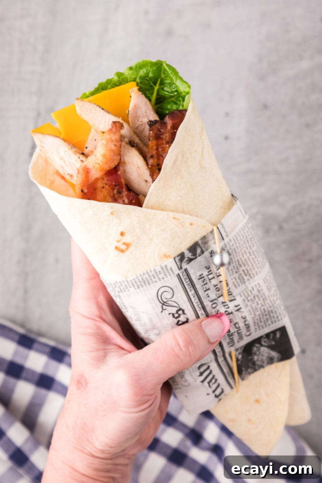 Signature Chicken Bacon Ranch Wrap 15 Hand holding a Chicken Bacon Ranch Wrap, showing the delicious filling peeking out, ready to be enjoyed.