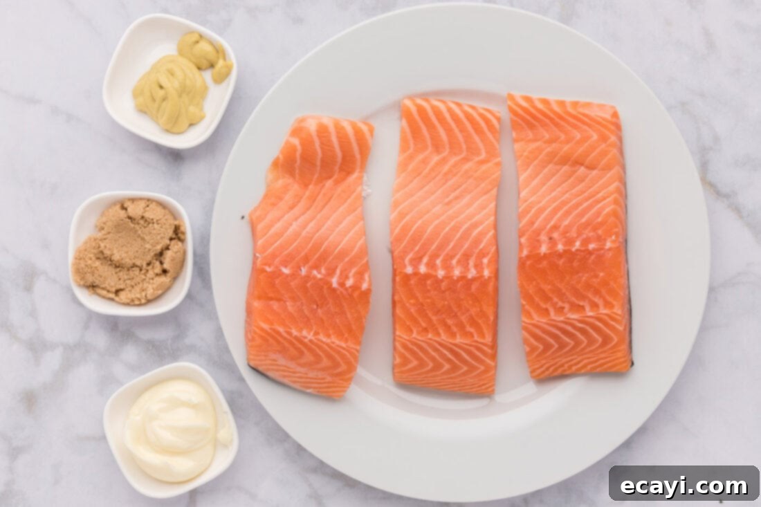 Caramelized Salmon 4 A bowl of brown sugar, a jar of Dijon mustard, a stick of butter, and fresh salmon fillets, showcasing the simple ingredients for Brown Sugar Salmon.
