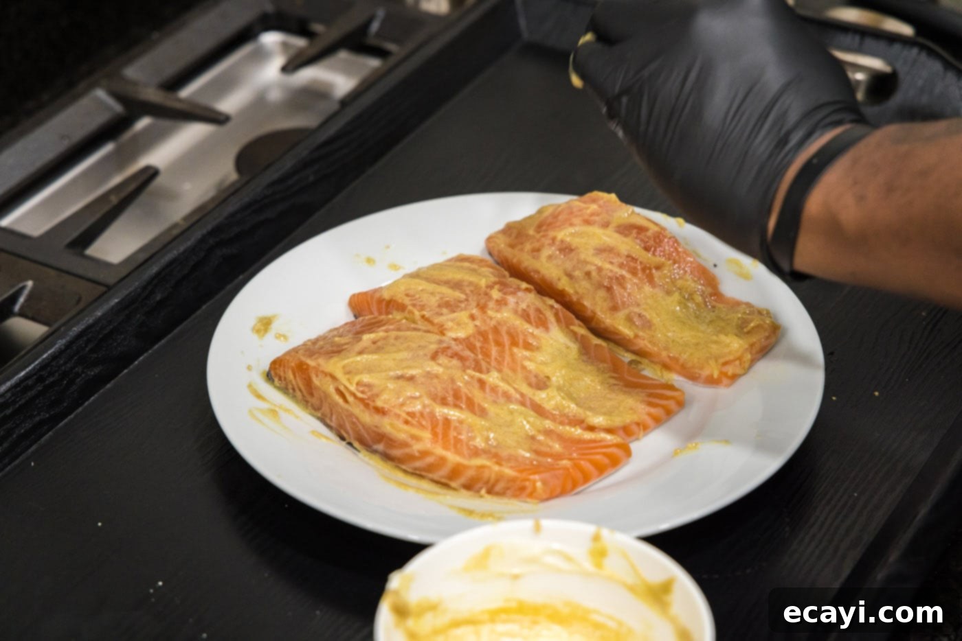 Caramelized Salmon 7 Three salmon fillets neatly arranged on a baking sheet, each generously topped with the Dijon brown sugar glaze.
