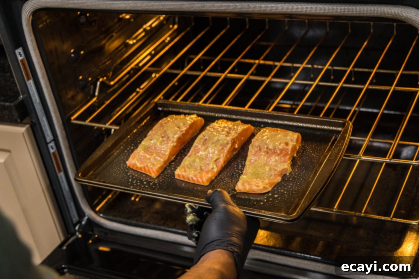 Caramelized Salmon 8 A hand carefully placing salmon fillets onto a baking sheet, ready to go into the oven.