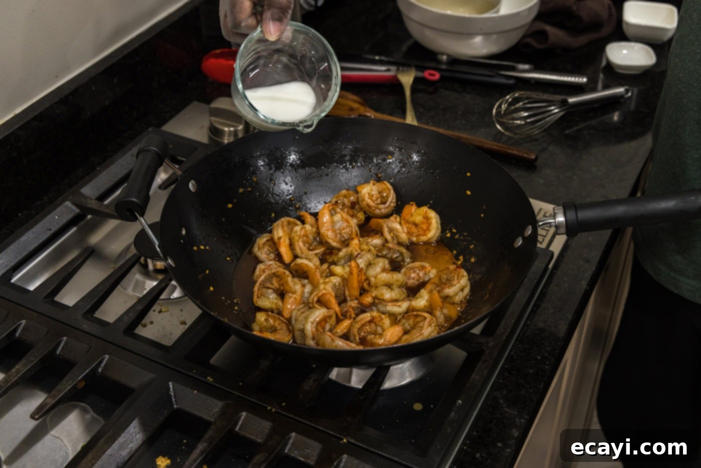 Fiery Hunan Shrimp 8 Pouring a cornstarch and water slurry into the Hunan shrimp and sauce mixture in the wok to thicken