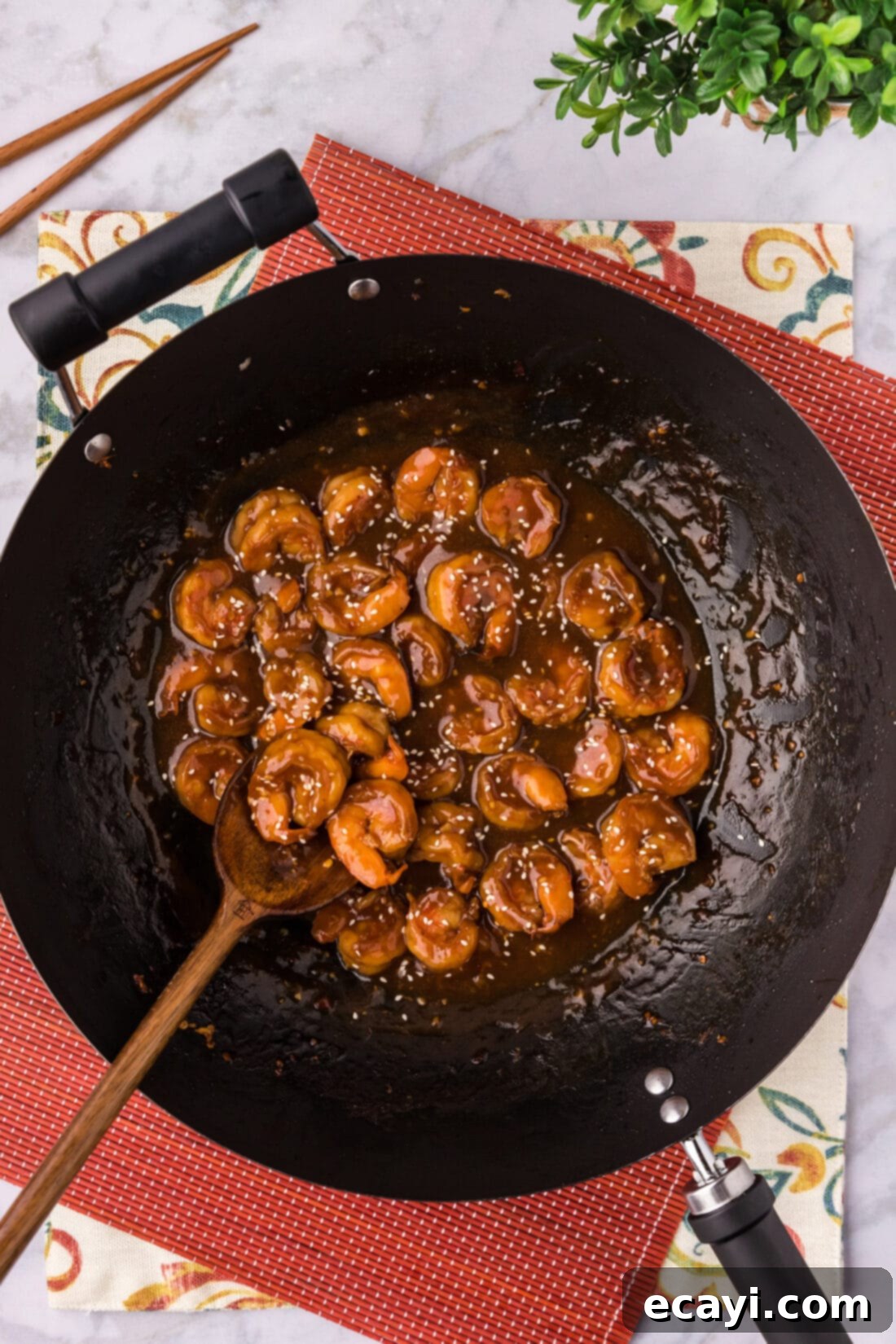 Fiery Hunan Shrimp 10 A skillet full of cooked Hunan Shrimp coated in a rich, spicy sauce, with a serving spoon resting in it