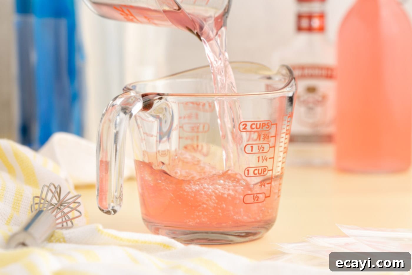 Poptails 5 pouring juice into a measuring cup with vodka, preparing the mix.
