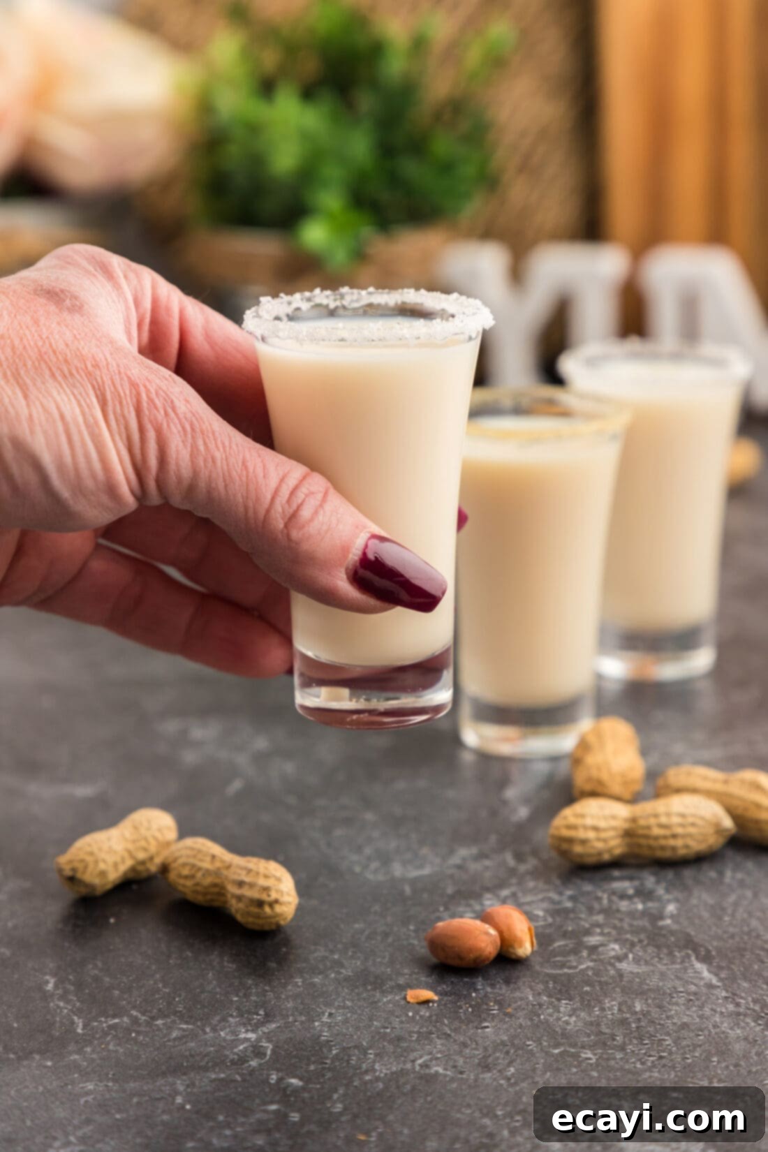 Salted Caramel Nut Blast 2 Hand holding up a Salted Nut Roll Shot, showing the salted rim and creamy liquid