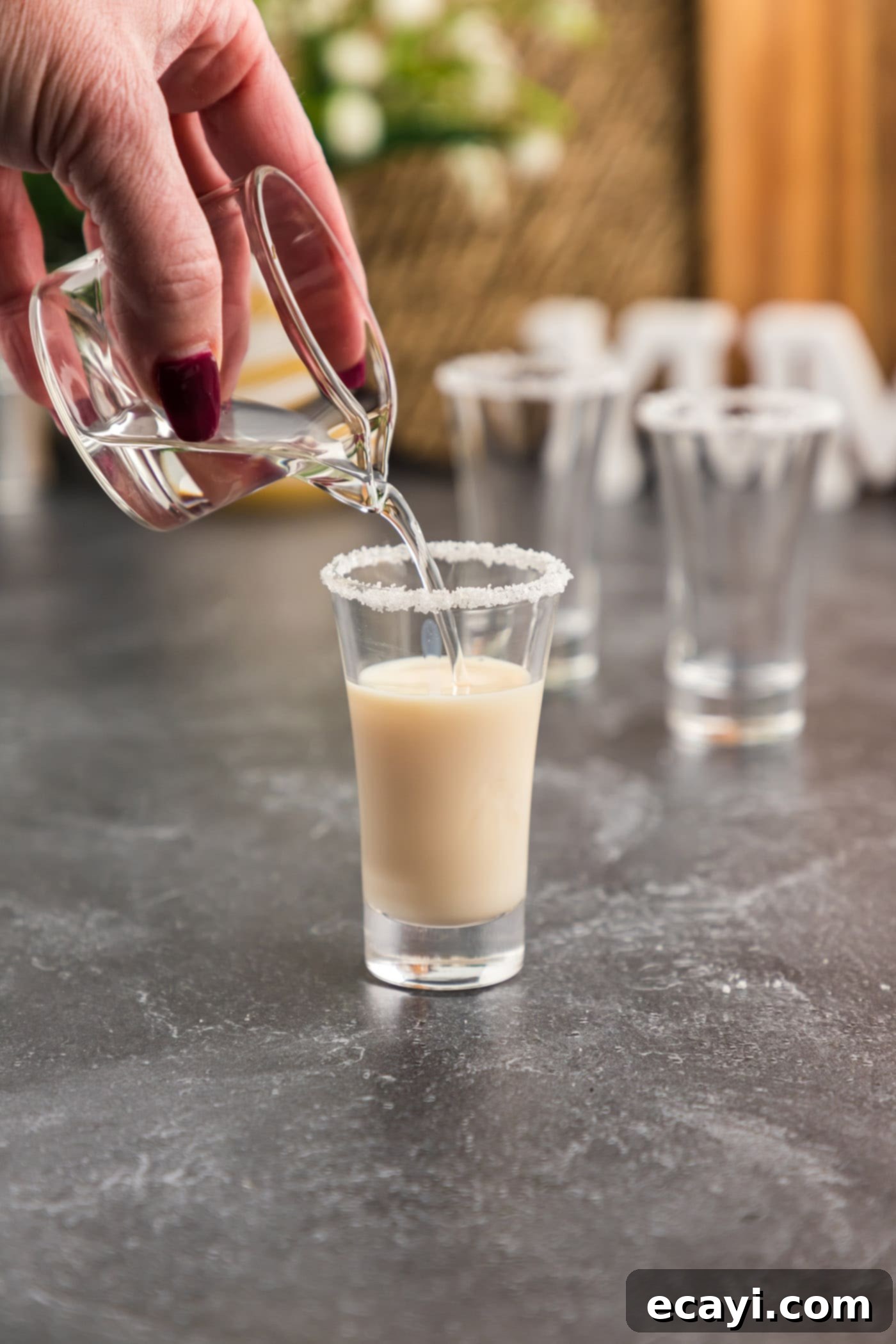 Salted Caramel Nut Blast 8 Pouring Butterscotch Schnapps into a shot glass, completing the mixture