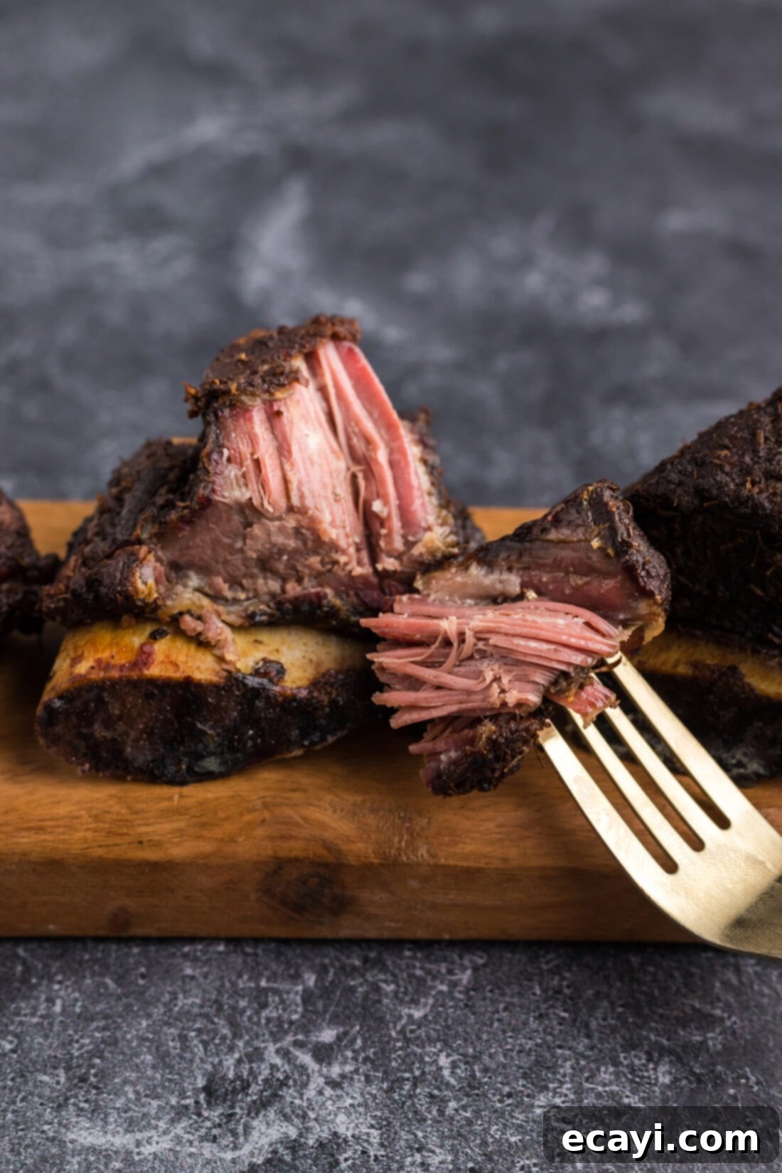 Melt in Your Mouth Smoked Short Ribs 2 Piece of Smoked Beef Short Rib on a fork, showcasing its tenderness and rich color