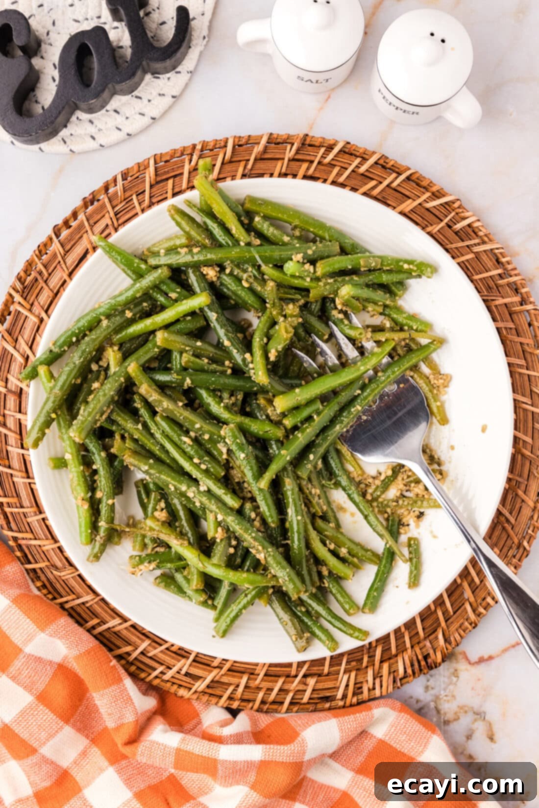 Garlic-Kissed Green Beans 10 Garlic Green Beans on a white plate with a fork, ready to be enjoyed