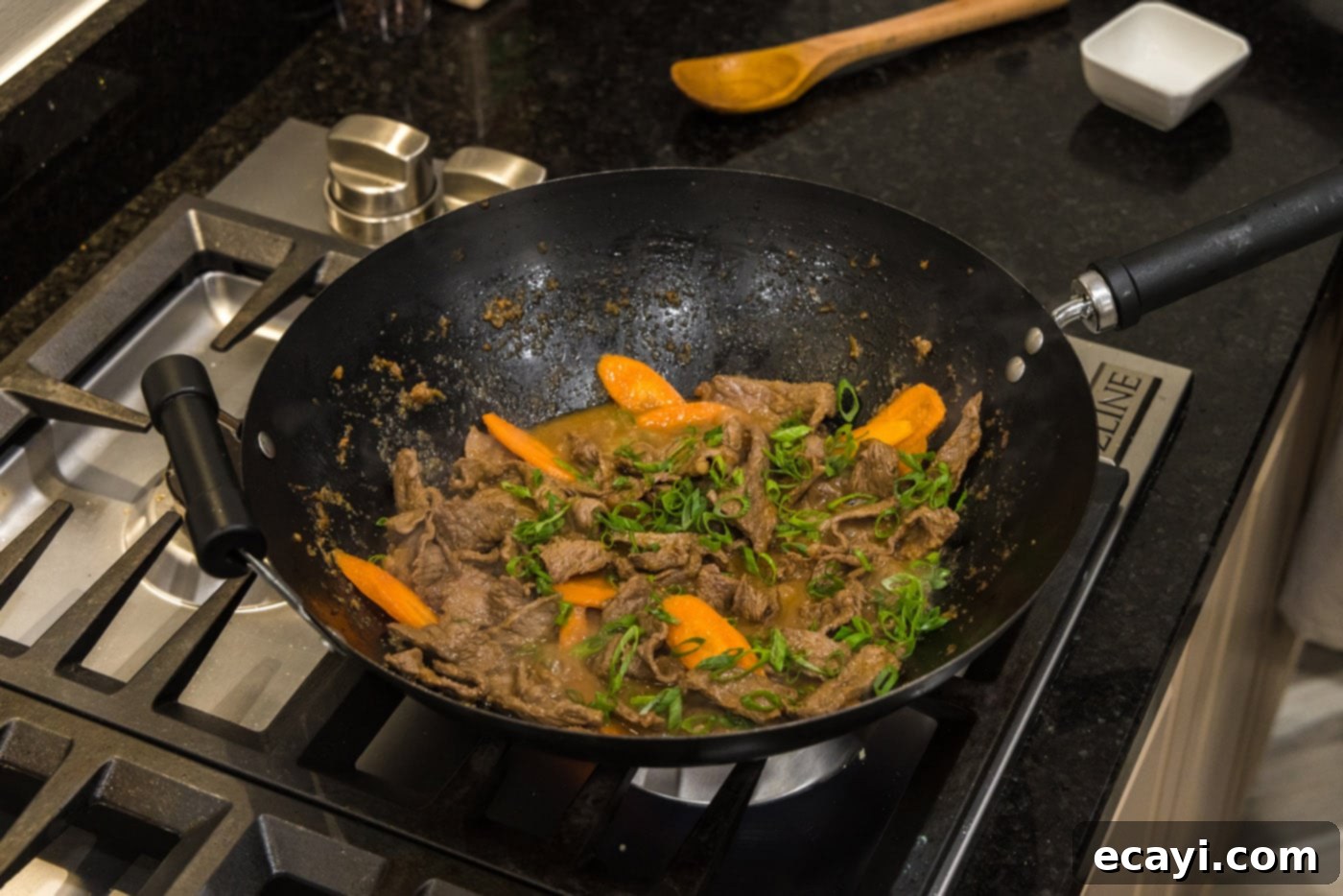 Classic Korean Beef Bulgogi 10 beef, sliced carrots, and green onions in a wok