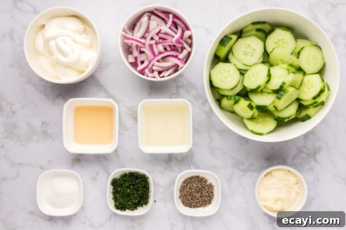 Cool and Creamy Cucumbers 4 A collection of fresh ingredients laid out on a wooden board, including cucumbers, red onions, dill, sour cream, and mayonnaise, ready for making creamy cucumber salad.