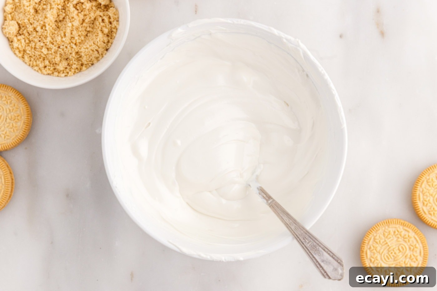 No-Bake Golden Oreo Bliss 14 Melted, smooth white chocolate wafers in a bowl, ready for dipping.