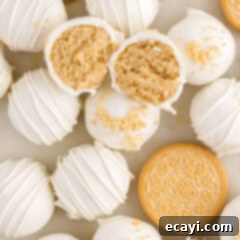 No-Bake Golden Oreo Bliss 18 Close up photo of a Golden Oreo Truffle cut in half resting on top of more Golden Oreo Truffles
