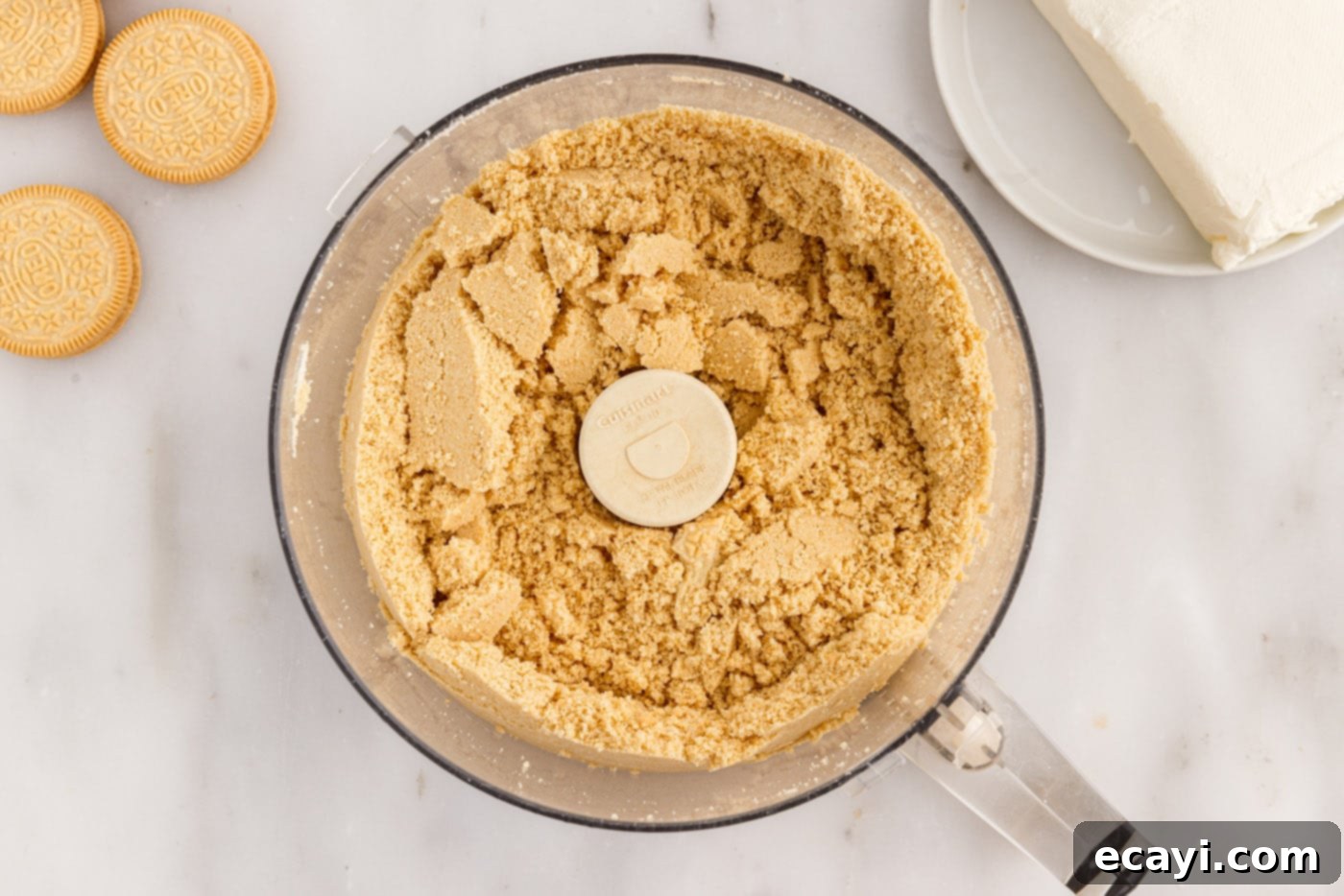 No-Bake Golden Oreo Bliss 6 Finely crushed Golden Oreo cookie crumbs in a food processor bowl.