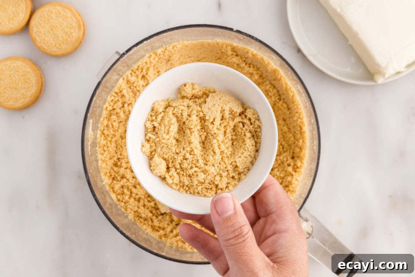 No-Bake Golden Oreo Bliss 7 A small bowl containing reserved cookie crumbs for decoration.