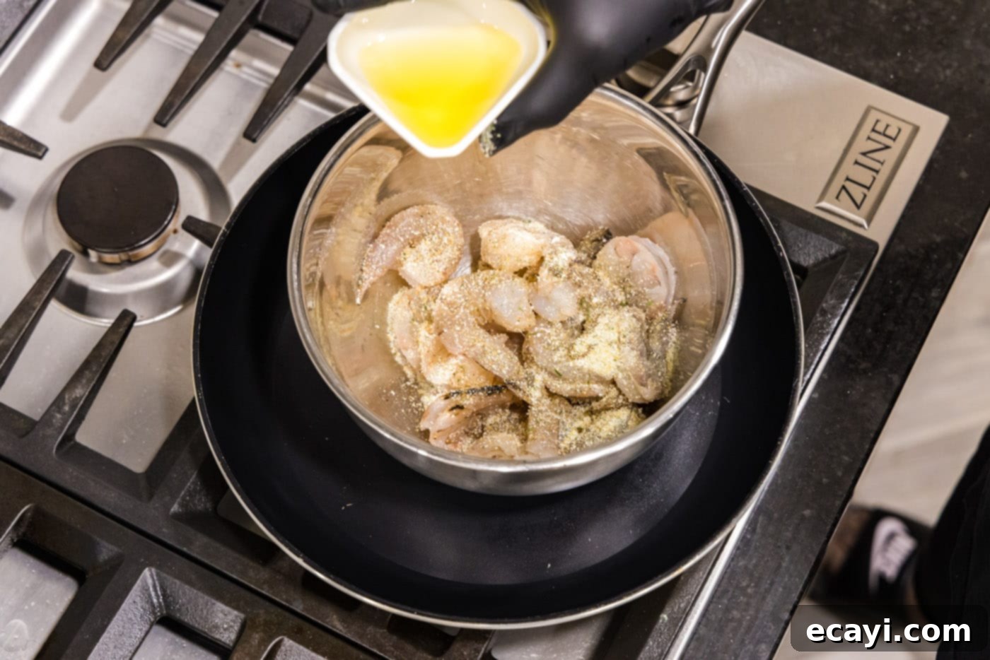 Shrimp Alfredo Bliss 5 tossing raw shrimp with olive oil and garlic salt in a bowl, preparing for cooking
