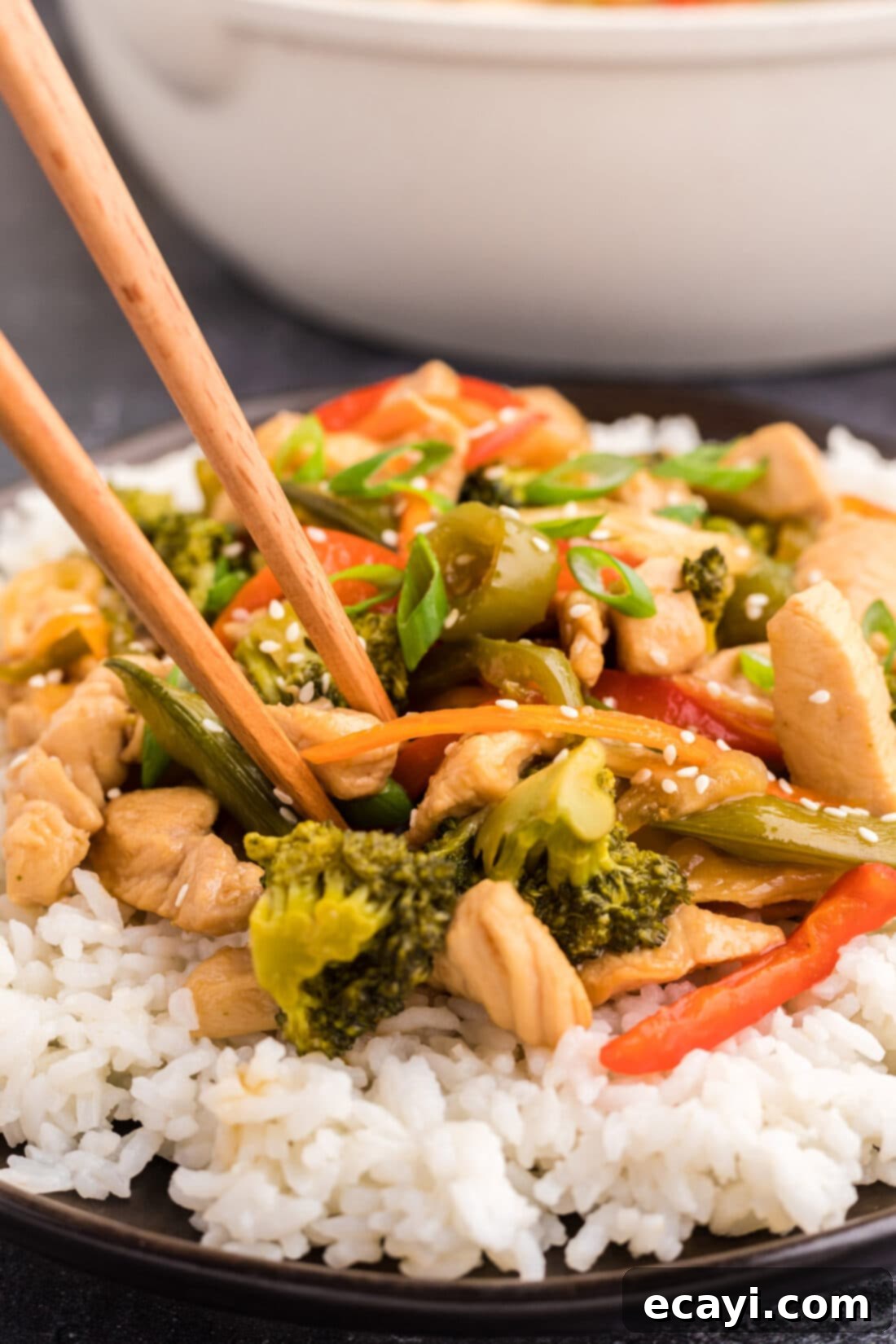 Sticky Honey Garlic Chicken Stir-Fry 3 Close up photo of Honey Garlic Chicken Stir Fry on a plate over rice with chopsticks