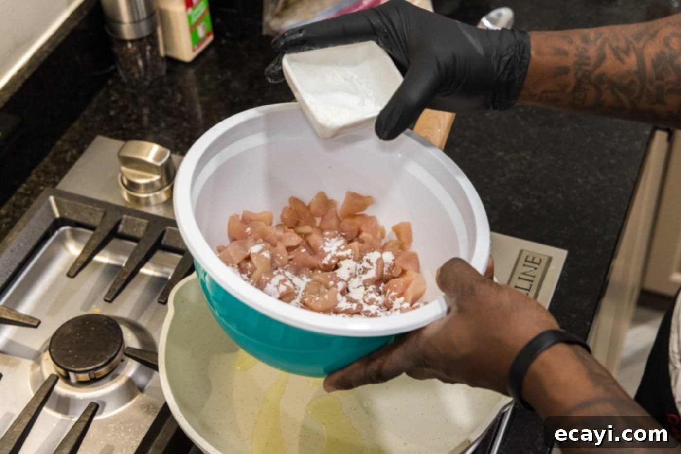 Sticky Honey Garlic Chicken Stir-Fry 5 adding cornstarch to cubed chicken in a bowl