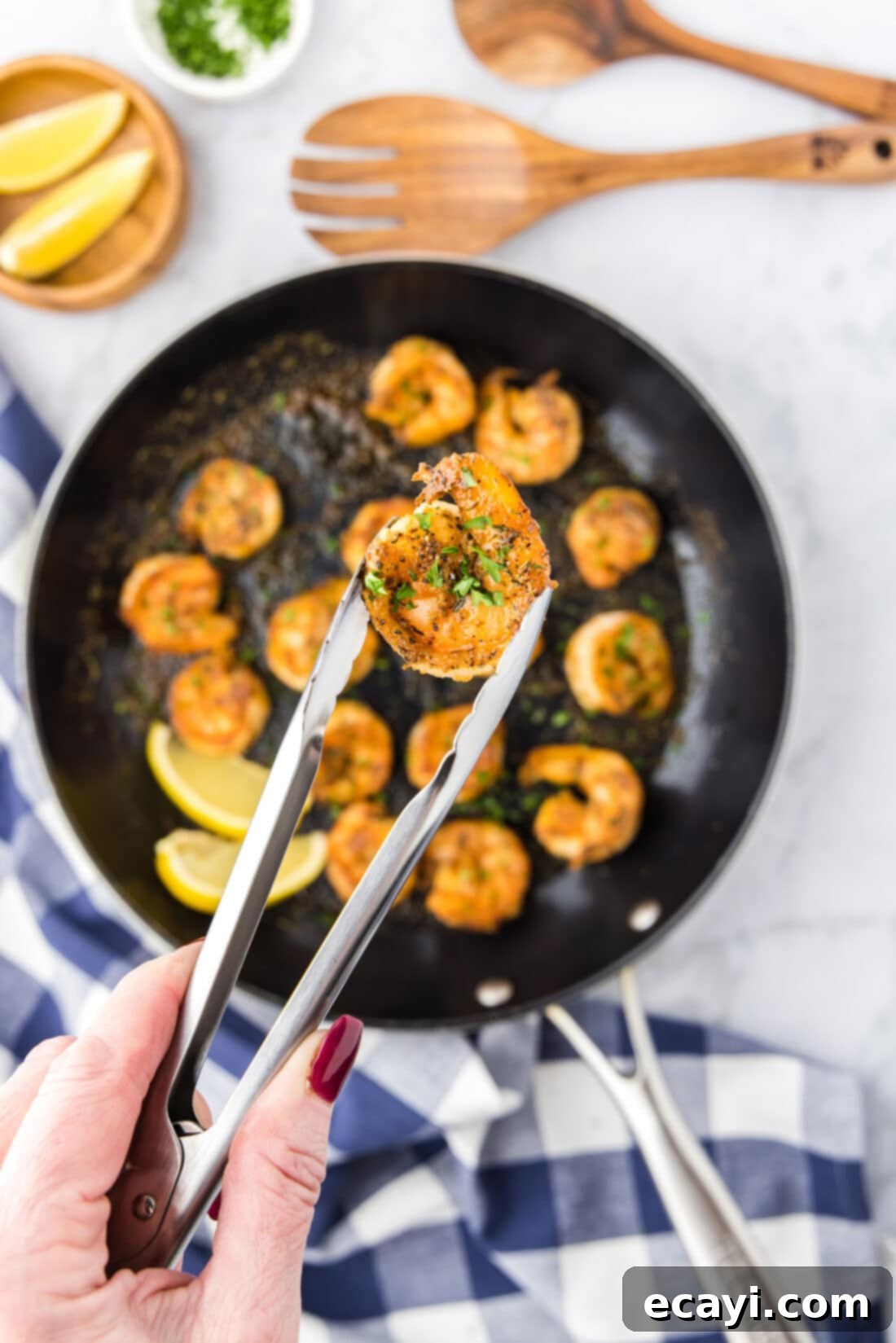 Fiery Cajun Prawns 10 Tongs holding a Cajun Shrimp