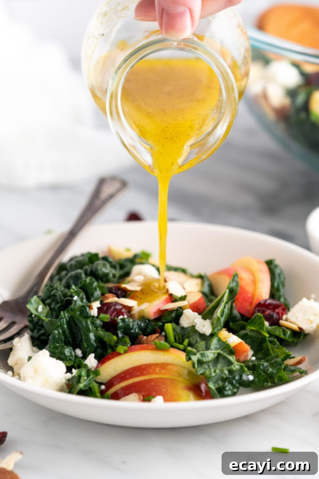Zesty Lemon Vinaigrette 2 Lemon Salad Dressing being poured over a Kale Salad