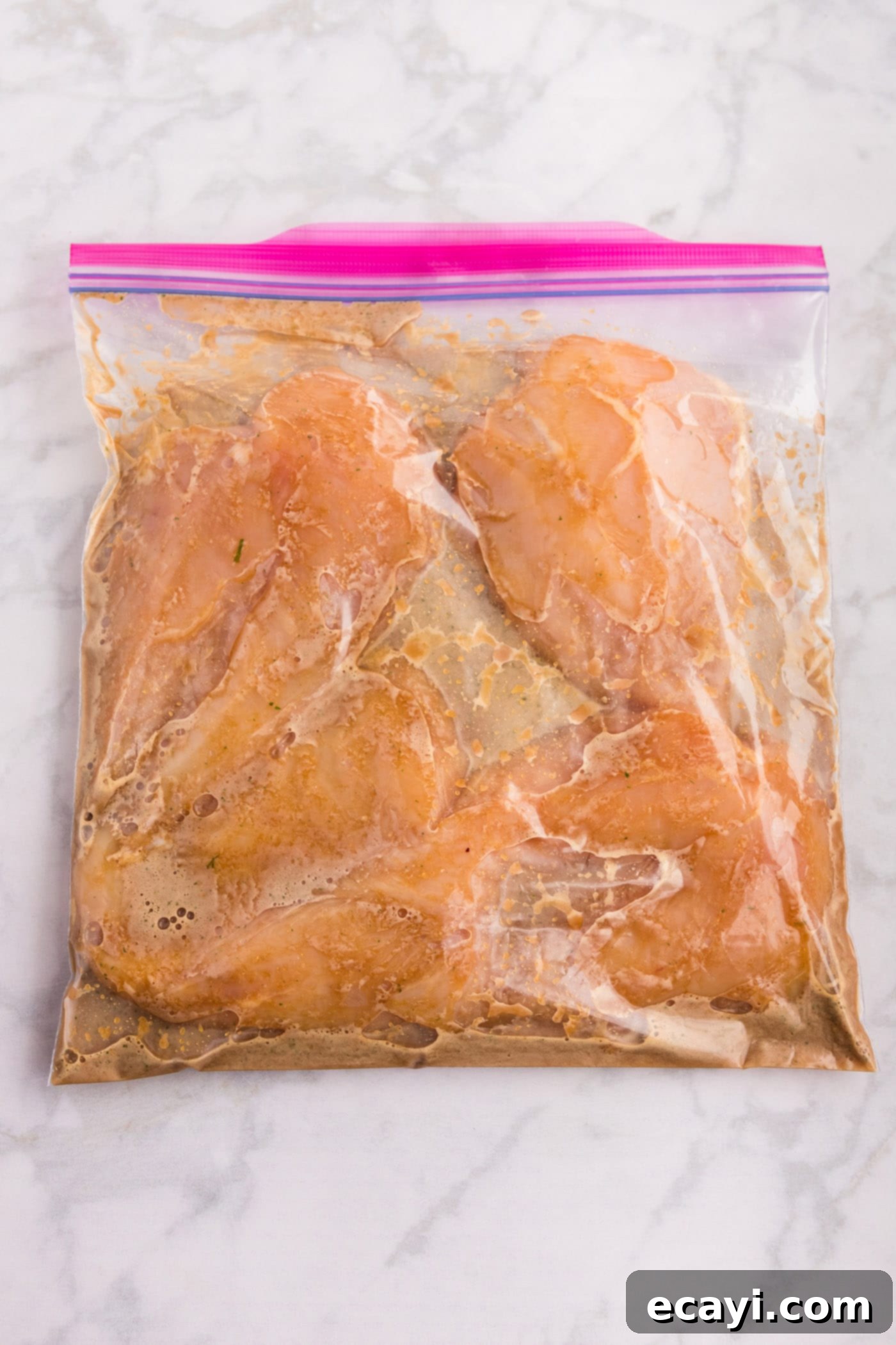 Delicious Honey Garlic Chicken Marinade 7 Chicken breasts soaking in the honey garlic sauce inside a zip-top bag, ready for marination.