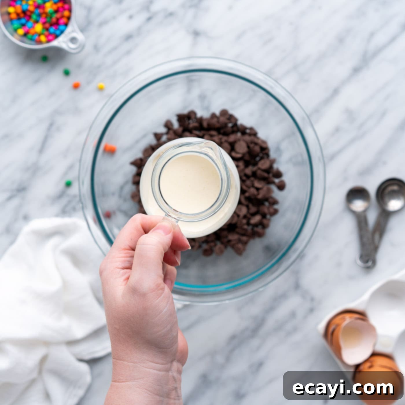 Dark Matter Delights 16 Adding heavy whipping cream to semi-sweet chocolate chips in a bowl for ganache preparation.