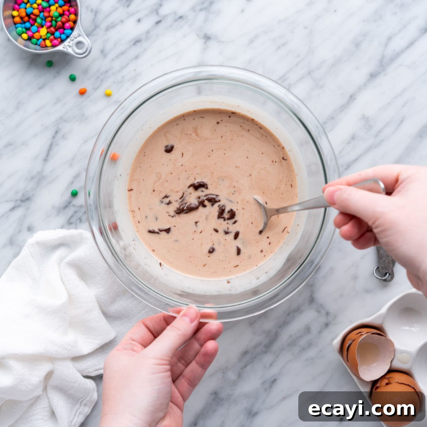 Dark Matter Delights 17 Mixing chocolate chips and heavy whipping cream gently with a spoon to create smooth ganache.