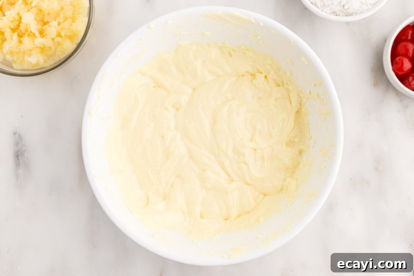 Billionaire Bliss Cake 10 Cream cheese pudding mixture in a bowl, smooth and thickened, ready to be spread over the cake.