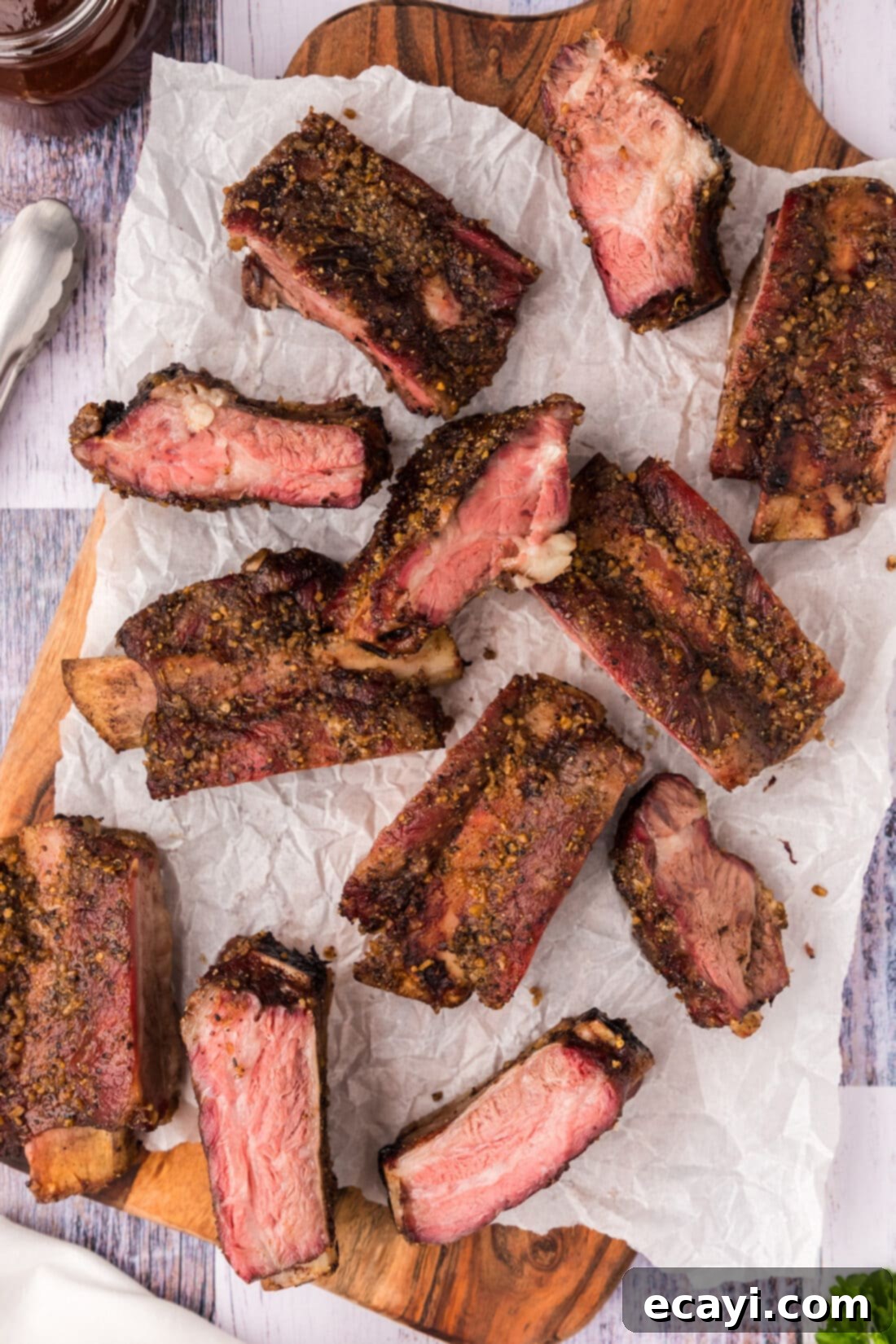 Pitmaster's Smoked Beef Ribs 2 Smoked Beef Ribs resting on a wooden platter covered in parchment paper