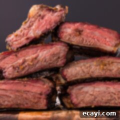 Pitmaster's Smoked Beef Ribs 12 Close up photo of Smoked Beef Ribs stacked on a wooden platter