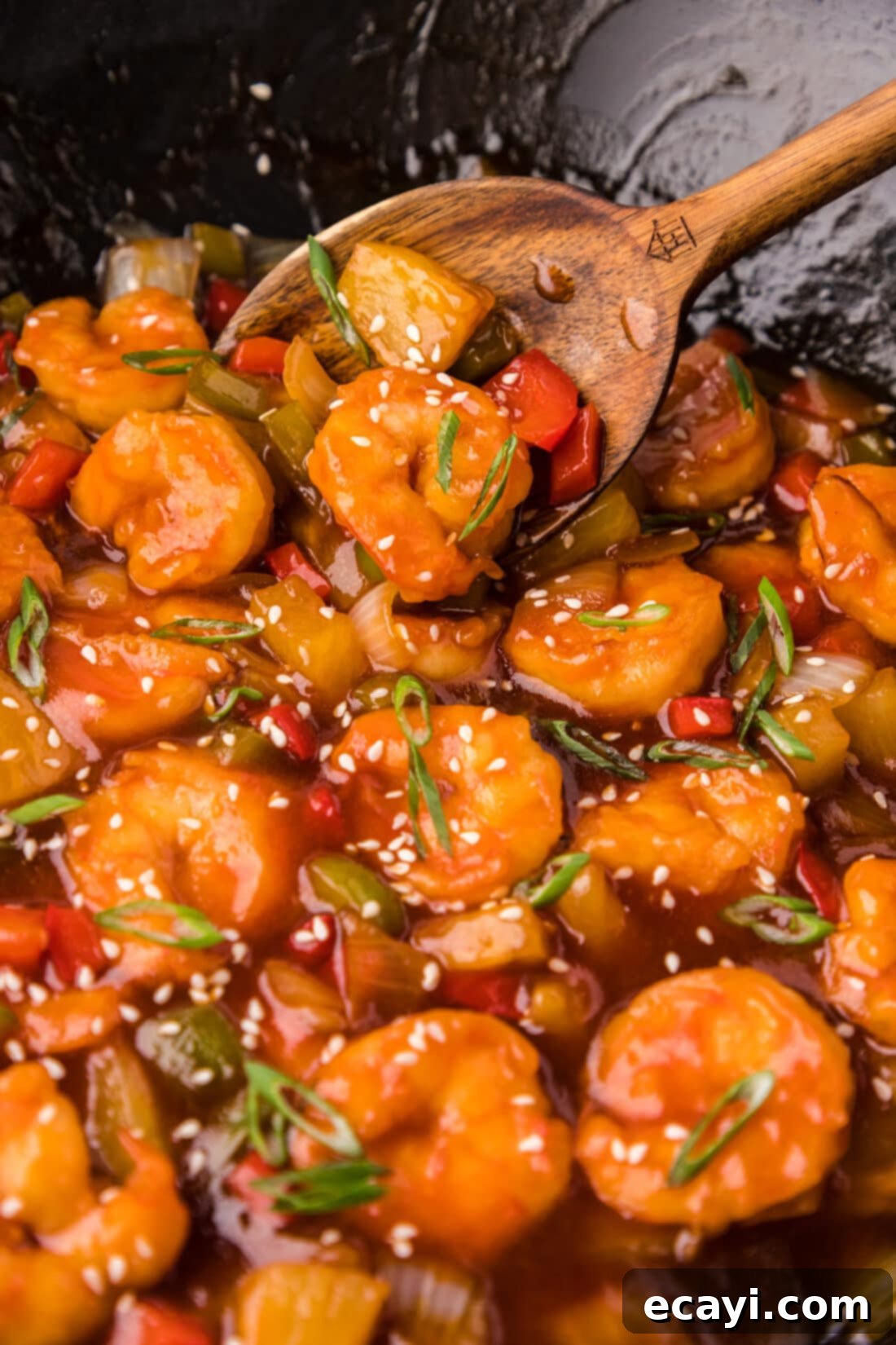 Tangy Prawn Delight 2 Close up photo of Sweet and Sour Shrimp in a wok with a spoon, highlighting the crispy texture and vibrant sauce.