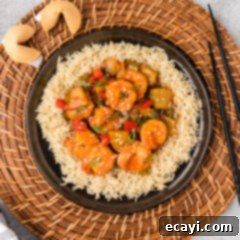 Tangy Prawn Delight 15 Plate of Sweet and Sour Shrimp served over rice, garnished with green onions.