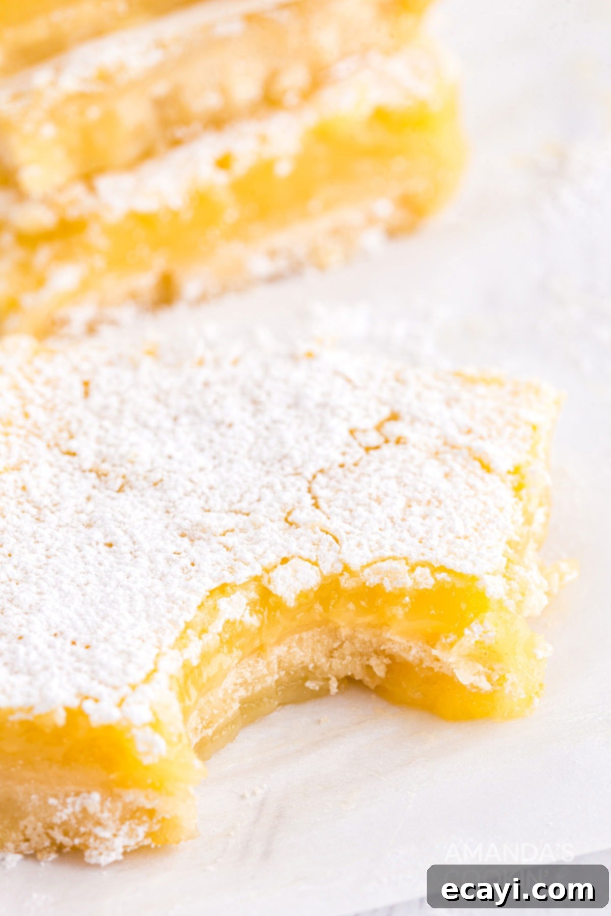 Six ingredients are all that's needed to make these delicious lemon bars. Perfect for any time of year and great for taking to parties. lemon bar with a bite out of it