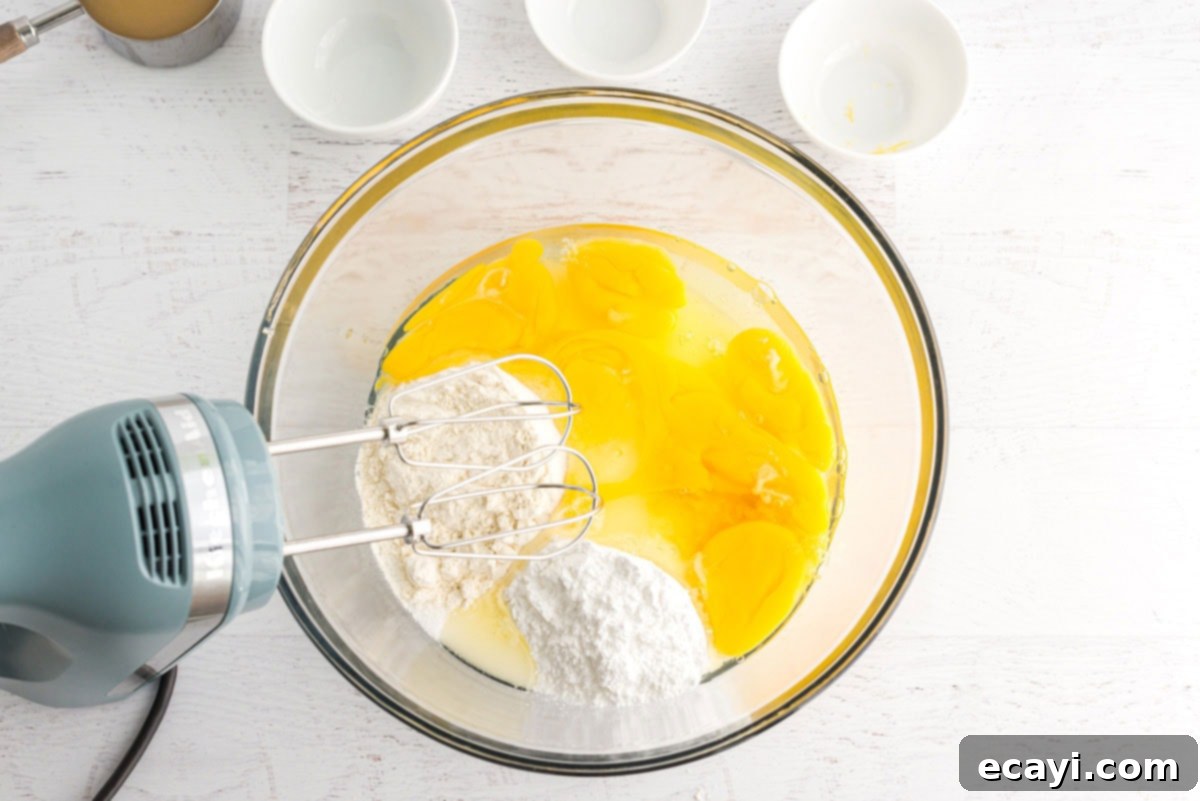Zesty Lemon Bars 6 eggs and other ingredients in a bowl with a mixer