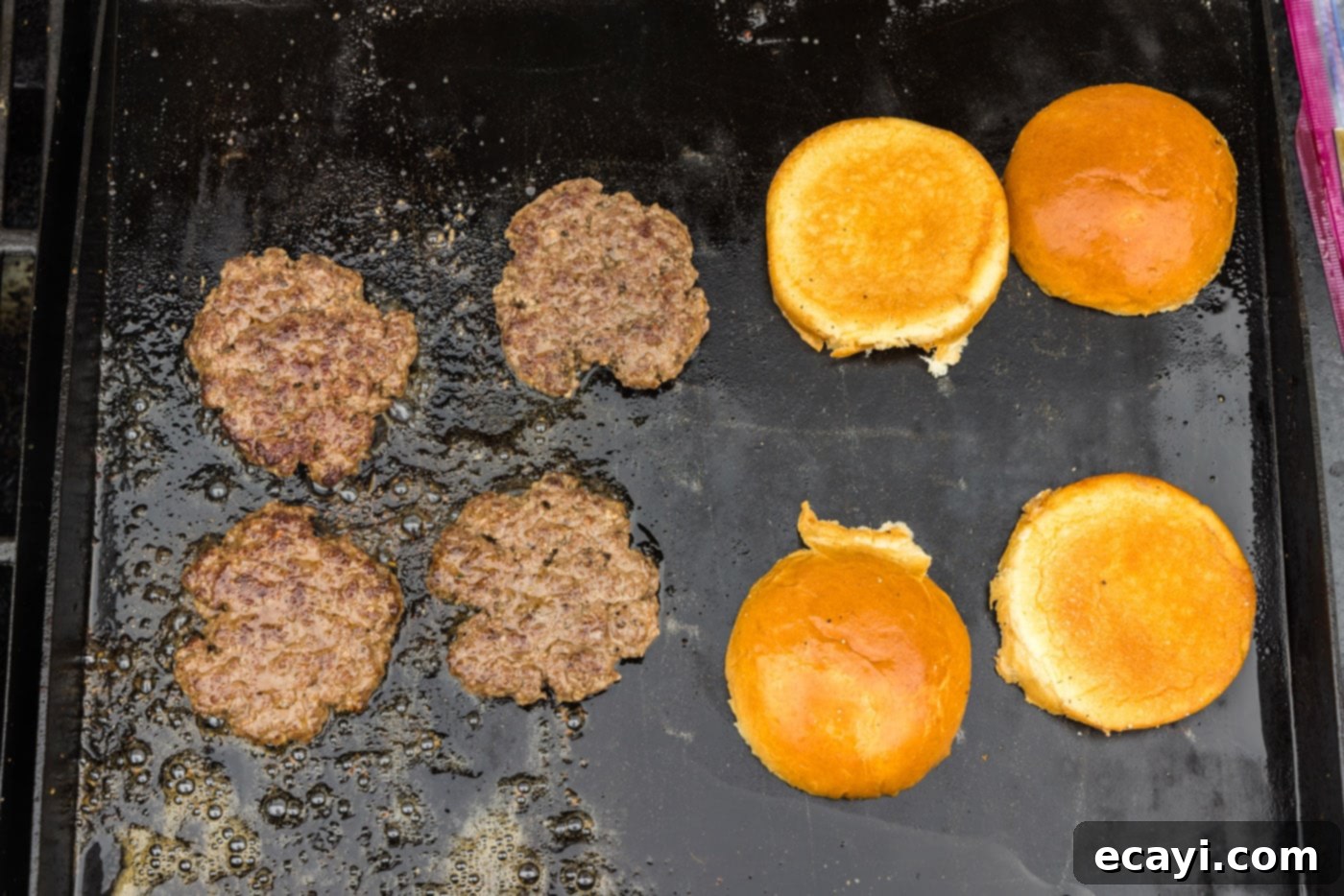 The Smash Burger 12 buns and burger patties on a griddle grate